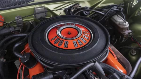 Крупный план 340-го четырехкамерного двигателя V-8 под капотом автомобиля Plymouth 'Cuda 340 цвета «зеленый металлик» 1970 года выпуска.
