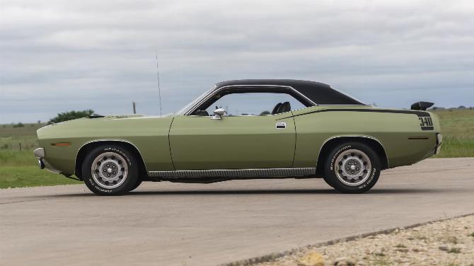 Вид слева на Plymouth 'Cuda 340 1970 года выпуска цвета лайм-зеленый металлик FF4 с черным виниловым верхом, спойлером на крышке багажника и 15-дюймовыми дисками Rallye