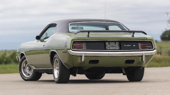 Вид слева сзади, 3q, на Plymouth 'Cuda 340 1970 года выпуска цвета лайм-зеленый металлик FF4 с черным виниловым верхом, колесами Rallye 15x7 и спойлером на крышке багажника.