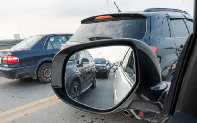 Зеркало заднего вида автомобиля, показывающее пробку